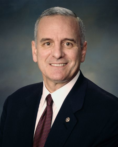Mark Dayton poses a picture in a black suit.